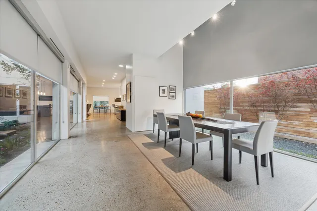 a dining room with furniture and a floor to ceiling window