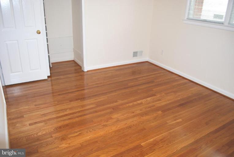 3517 Olympic Street Silver Spring, MD 20906 - Photo 13 of 30 a view of an empty room with wooden floor and a window