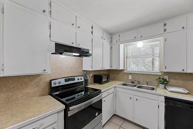 a kitchen with a sink appliances and cabinets