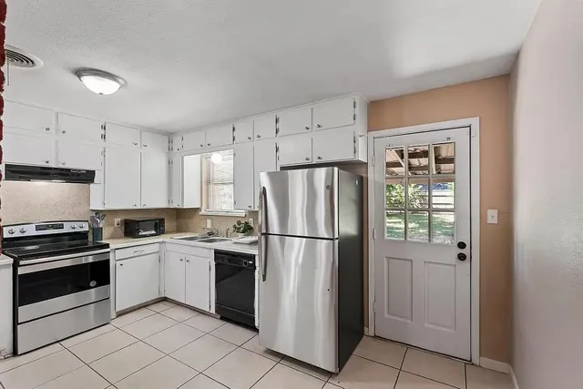 a kitchen with white cabinets and white appliances