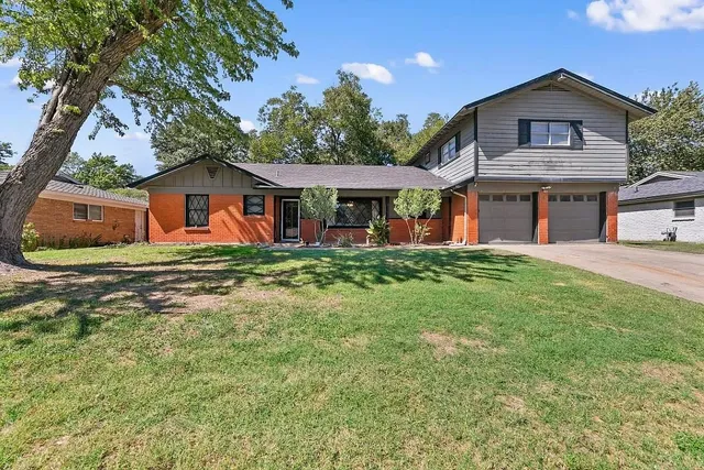 a front view of a house with a garden and trees
