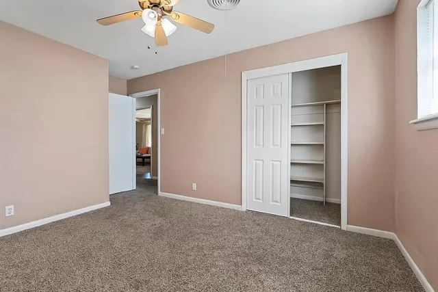 an empty room with closet and a window