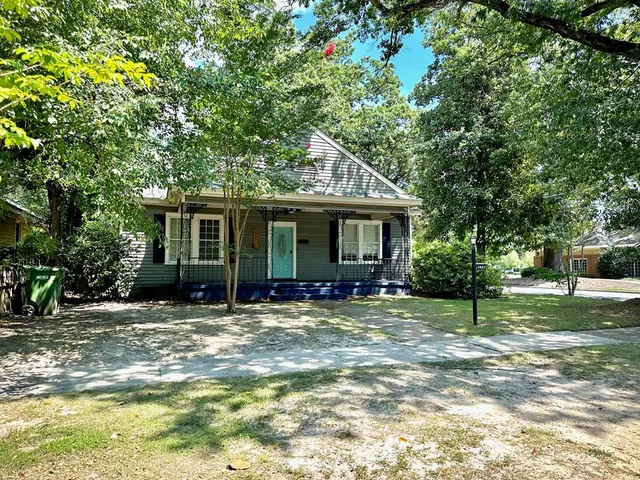 a view of a house with a tree in front of it