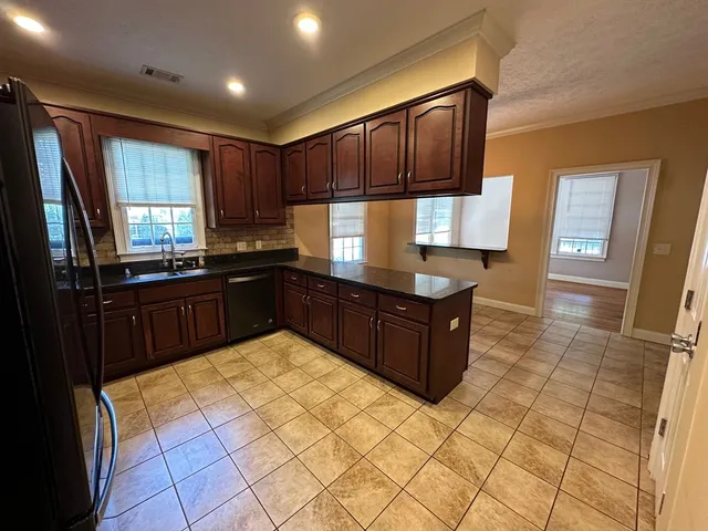 a kitchen with stainless steel appliances granite countertop a stove a sink and a refrigerator