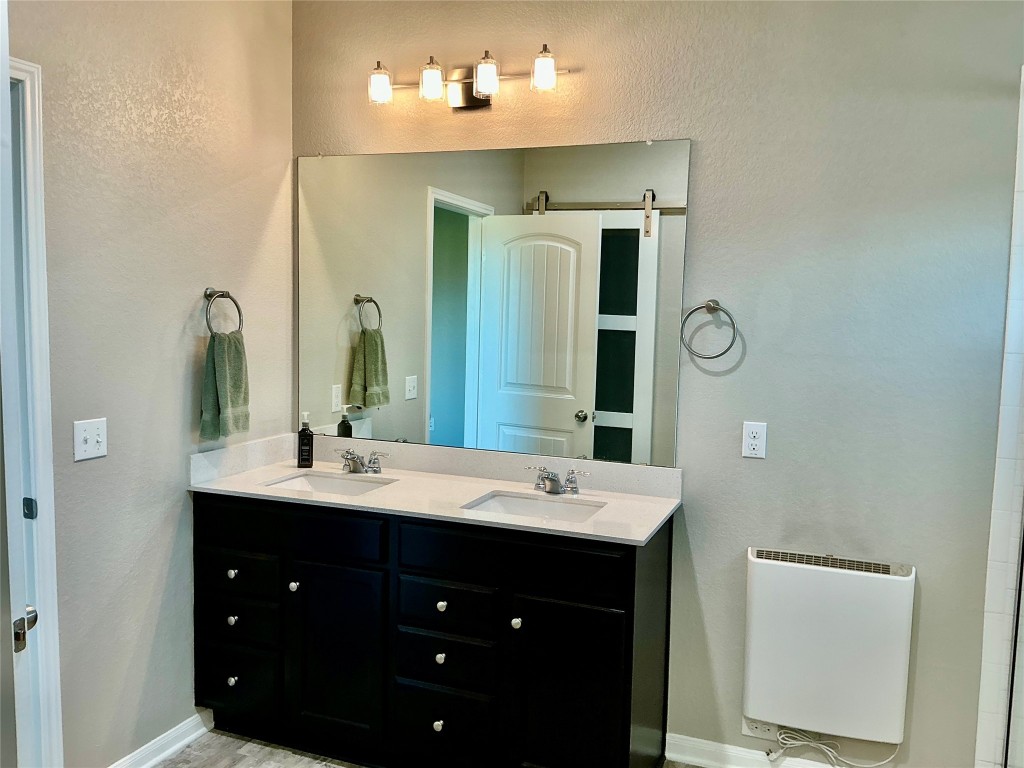 305 Rusk Bluff Avenue Leander, TX 78641 - Photo 25 of 34 a bathroom with a double vanity sink and a mirror