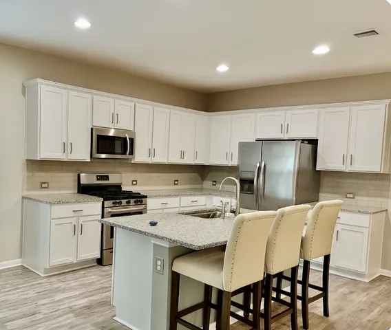 a kitchen with a sink stove top oven and refrigerator
