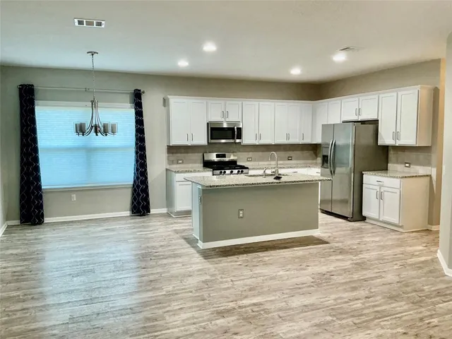 a kitchen with a refrigerator sink and cabinets