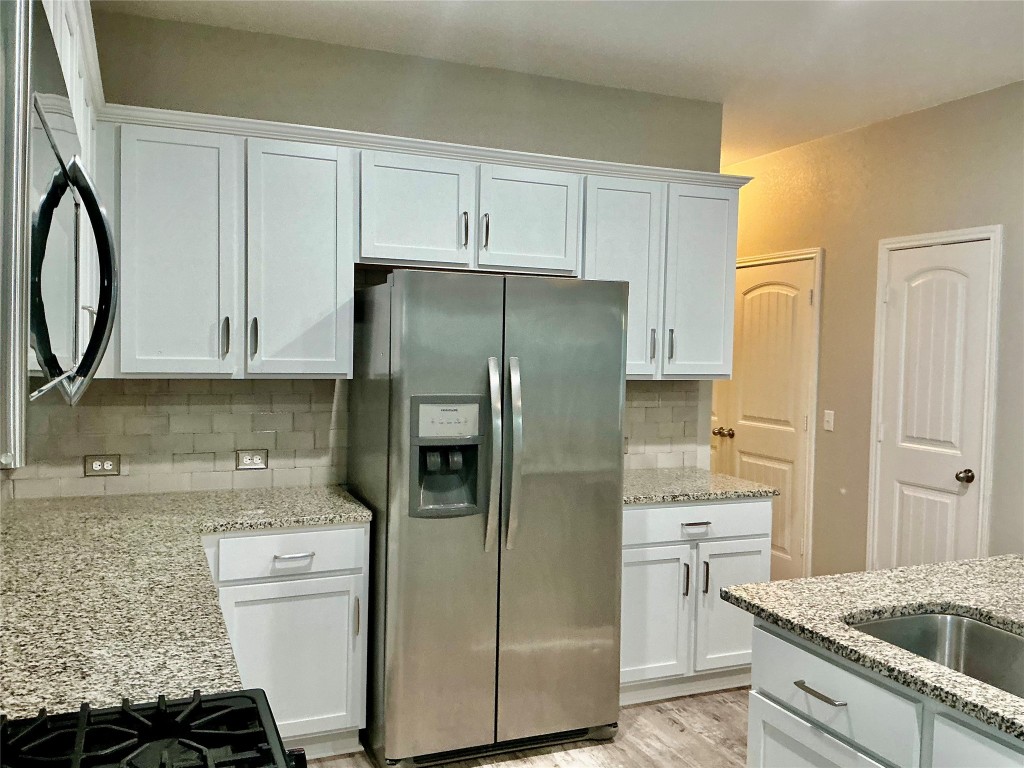 305 Rusk Bluff Avenue Leander, TX 78641 - Photo 10 of 34 a kitchen with a refrigerator sink and cabinets