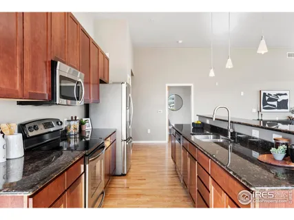 a kitchen with granite countertop a sink stove and cabinets