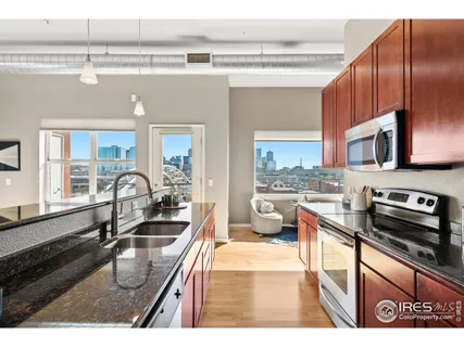 a kitchen with kitchen island granite countertop a sink stove and cabinets