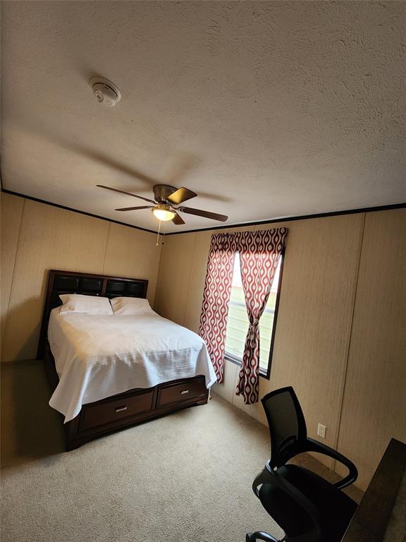 2234 County Road 1056 Celeste, TX 75423 - Photo 4 of 8 Bedroom with an office area, a textured ceiling, a ceiling fan, and light carpet