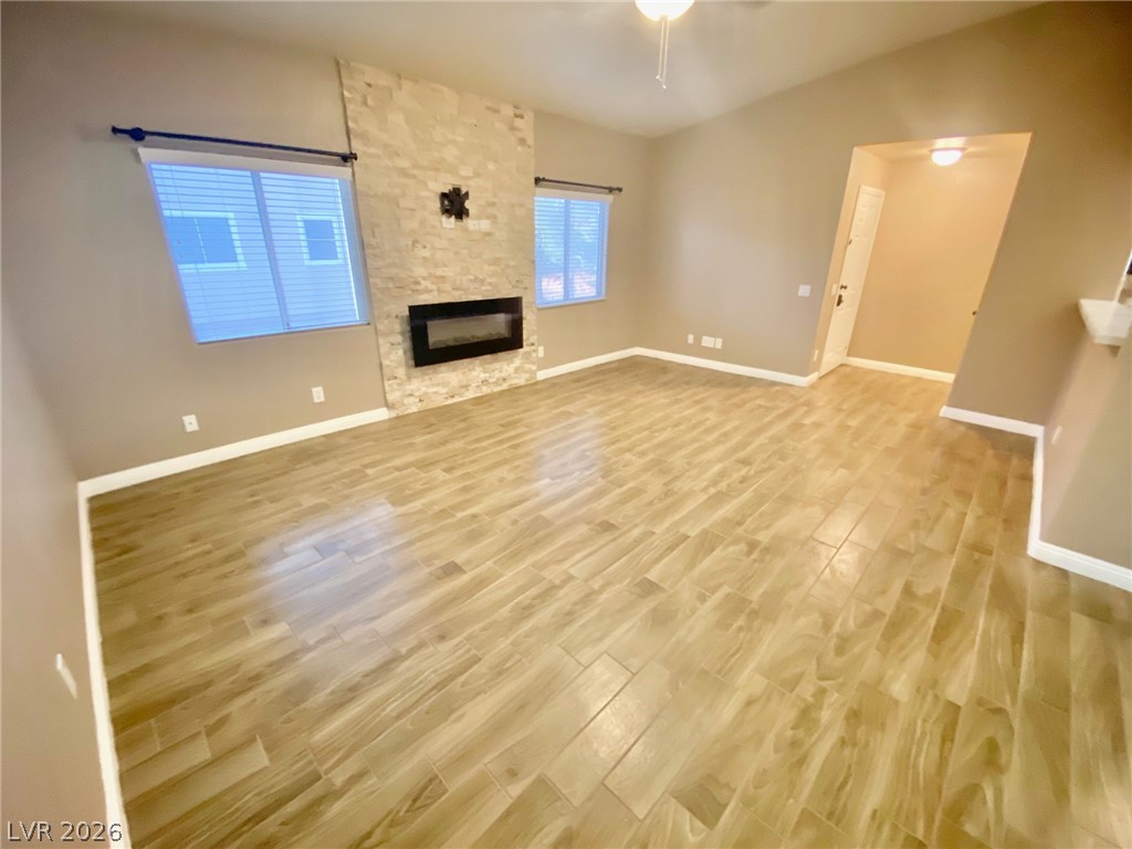 2000 Turquoise Ridge Street, Unit 204 Las Vegas, NV 89117 - Photo 12 of 29 A contemporary living room showcasing a sleek fireplace with a textured stone surround and elegant tile flooring.