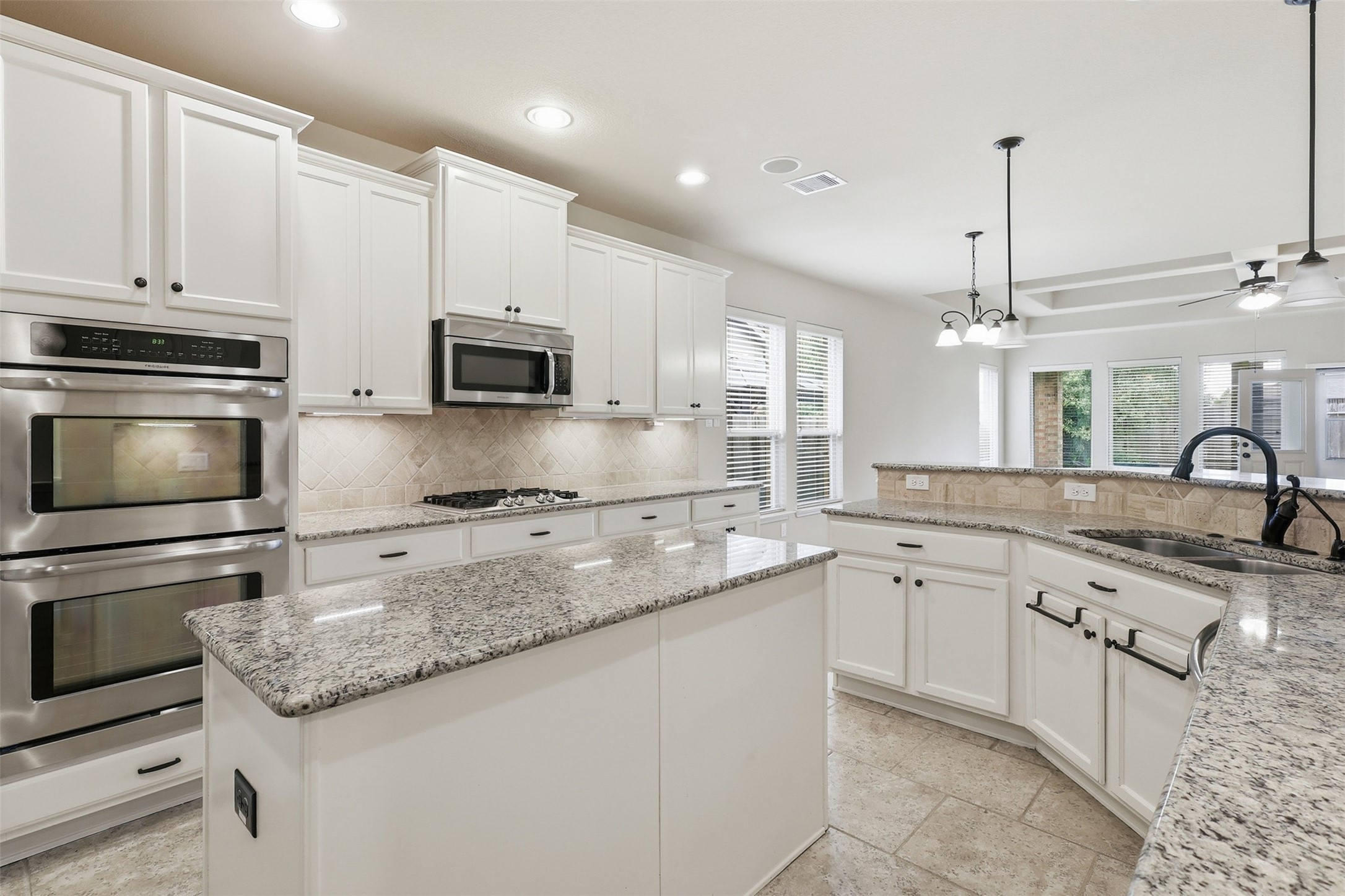 22943 Dale River Road Tomball, TX 77375 - Photo 7 of 29 a kitchen with granite countertop white cabinets and stainless steel appliances