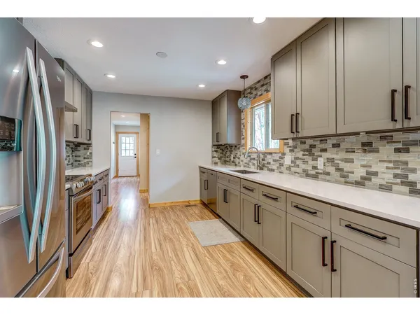 a kitchen with stainless steel appliances granite countertop a sink stove and refrigerator
