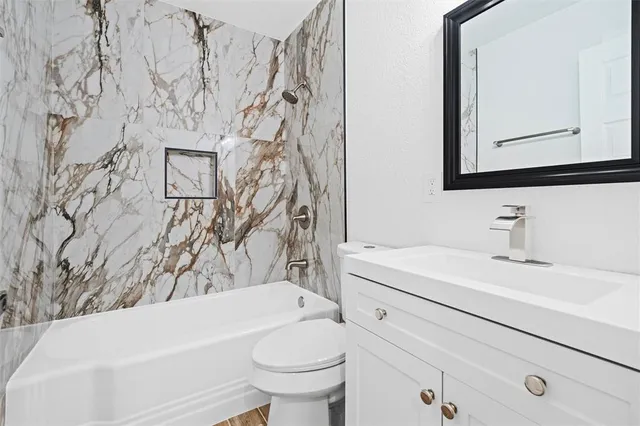 a bathroom with a sink toilet vanity and tub