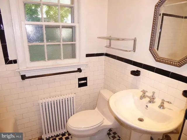 a bathroom with a sink a toilet and mirror
