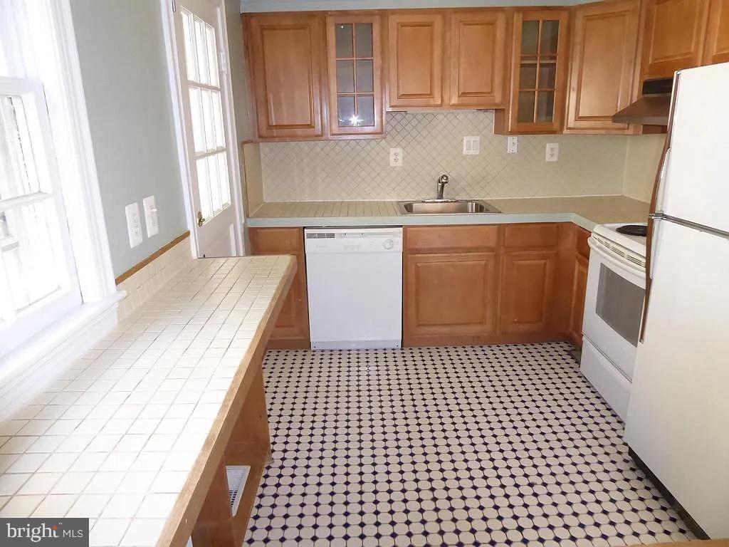4344 Ellicott Street Northwest Washington, DC 20016 - Photo 5 of 25 a kitchen with a sink a stove top oven and cabinets