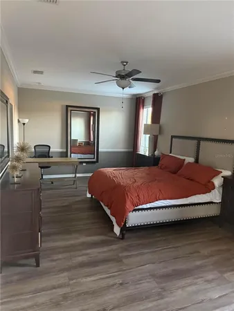 a spacious bedroom with a large bed and a chandelier