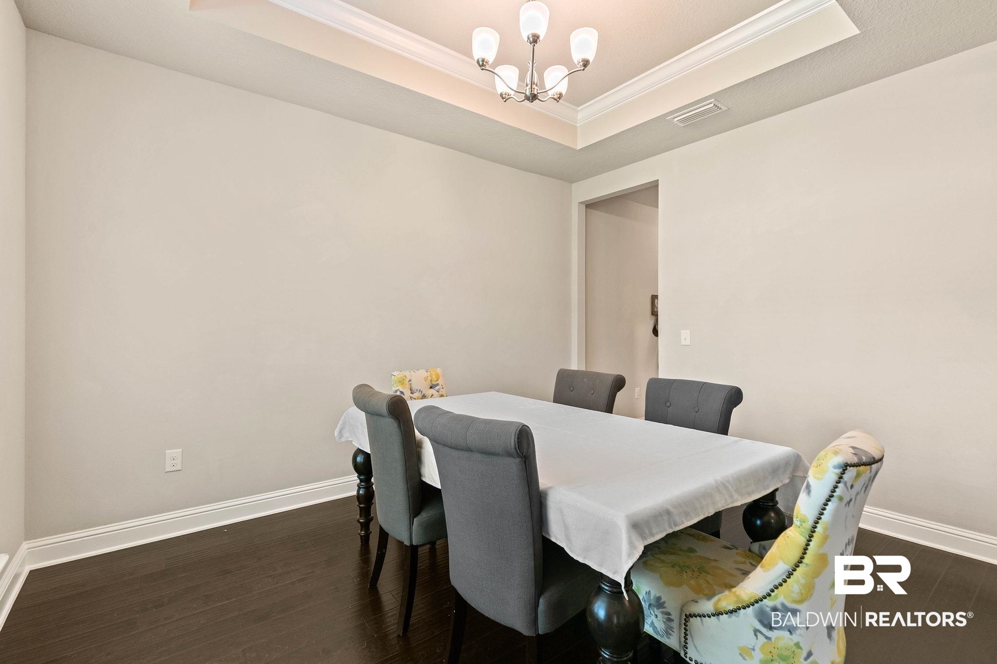 12750 B Jenkins Pit Road Daphne, AL 36527 - Photo 10 of 89 Dining area with a tray ceiling, ornamental molding, dark wood-type flooring, and a chandelier