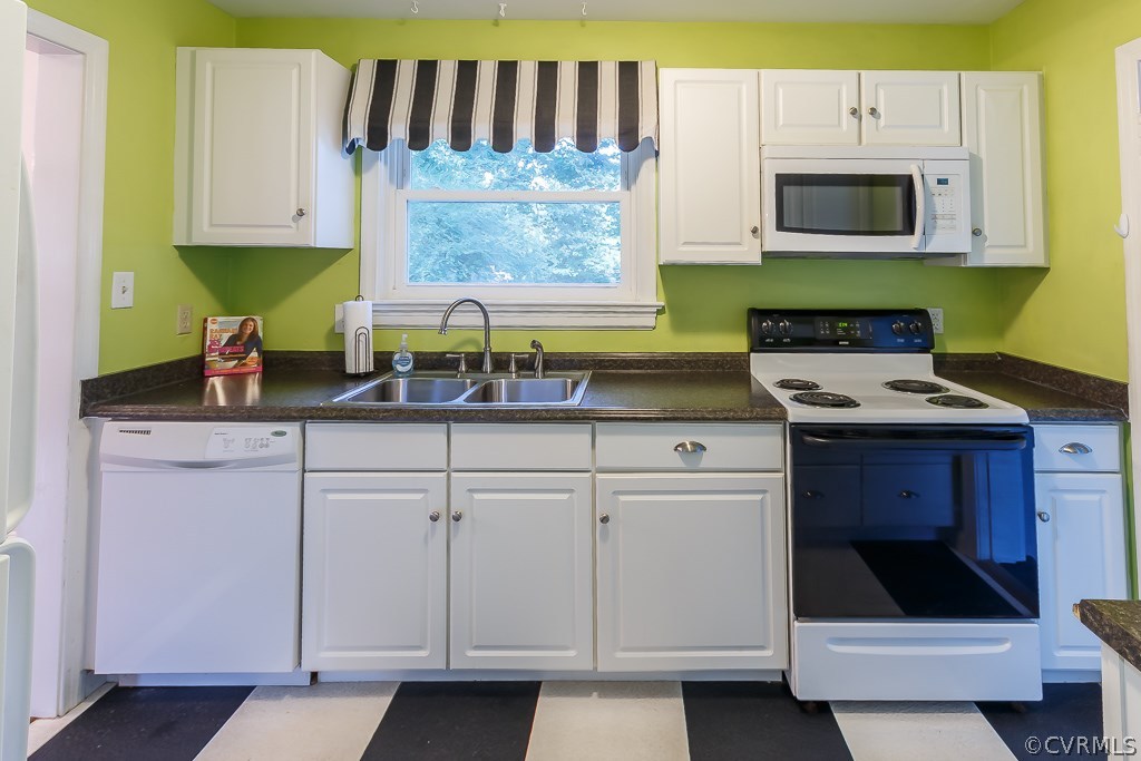 Kitchen has white cabinets and dishwasher.