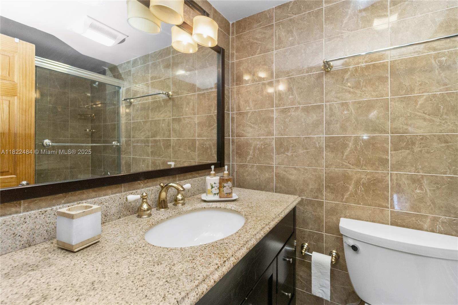 100 Lincoln Road, Unit 811 Miami Beach, FL 33139 - Photo 17 of 36 a bathroom with a granite countertop sink a toilet and a mirror