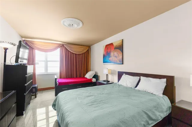 a bedroom with a bed and a flat screen tv