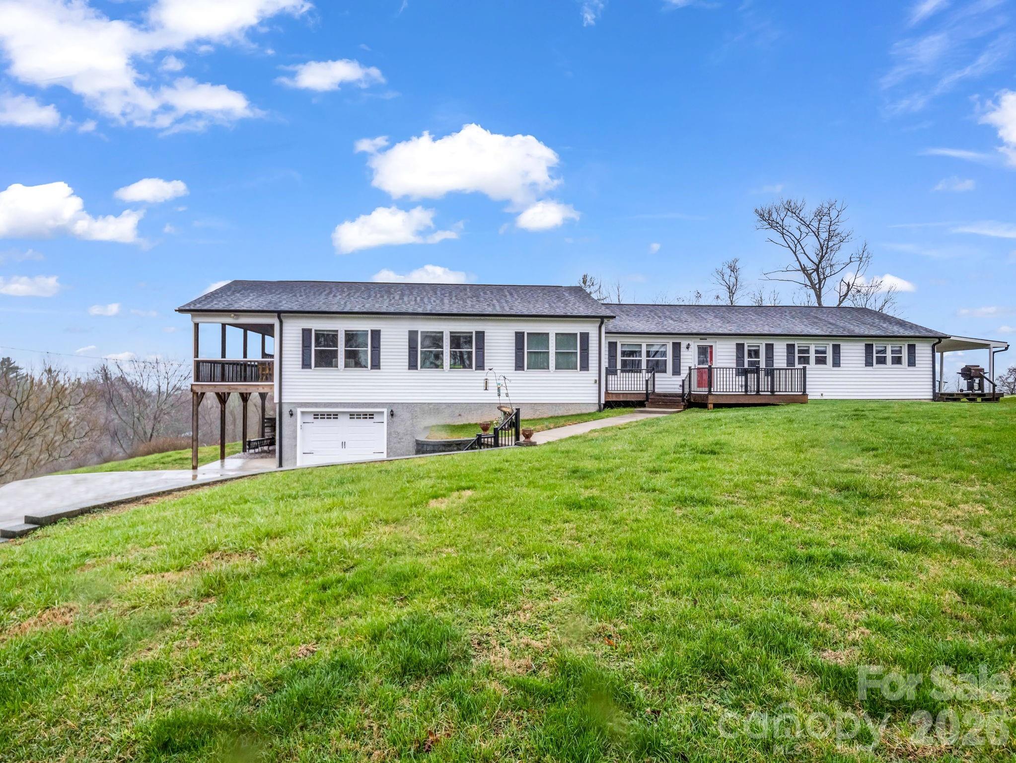 a view of a house with a big yard and large trees