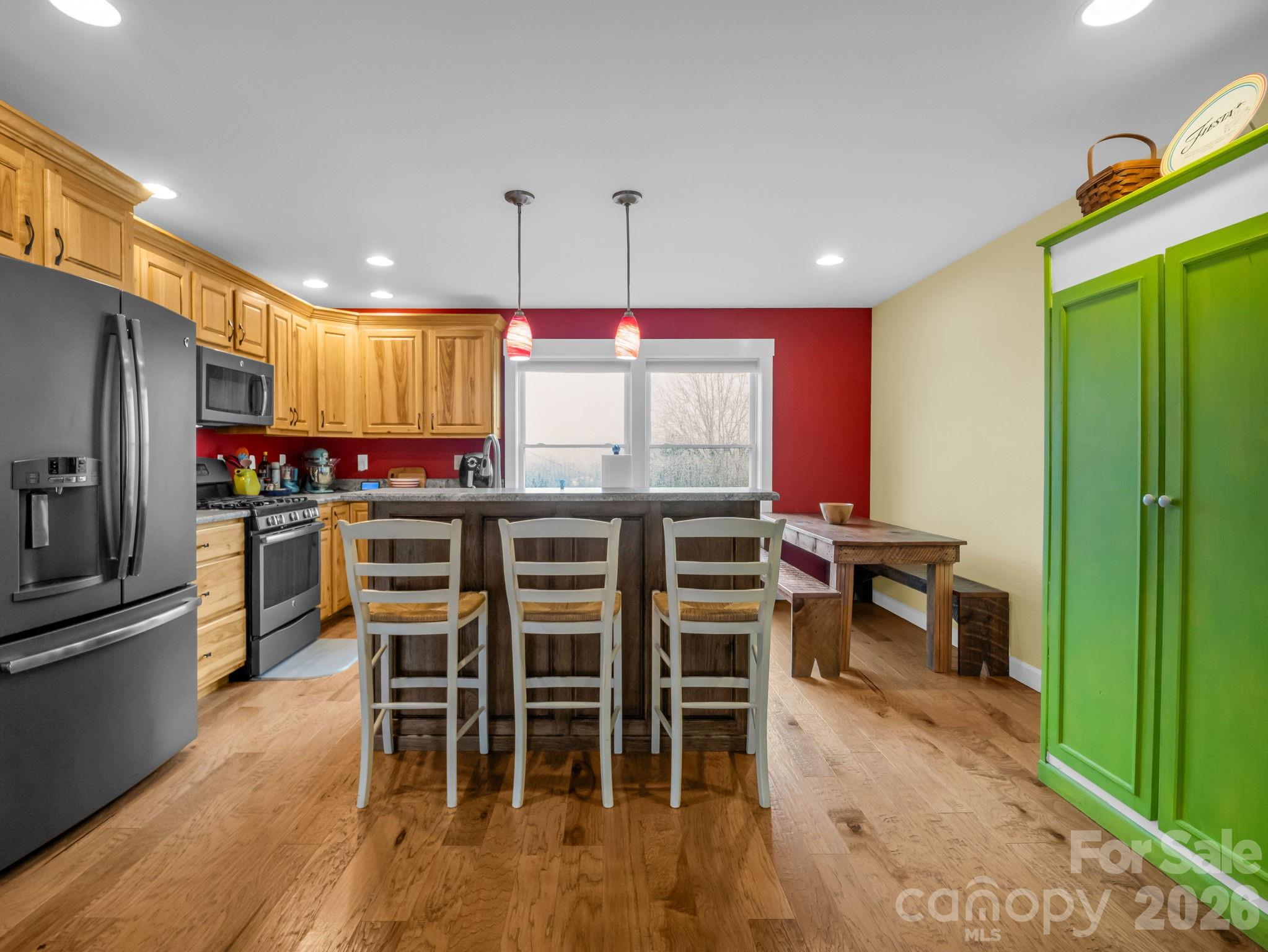 1086 Carters Ridge Road Spruce Pine, NC 28777 - Photo 26 of 48 a kitchen with stainless steel appliances a dining table chairs stove and refrigerator