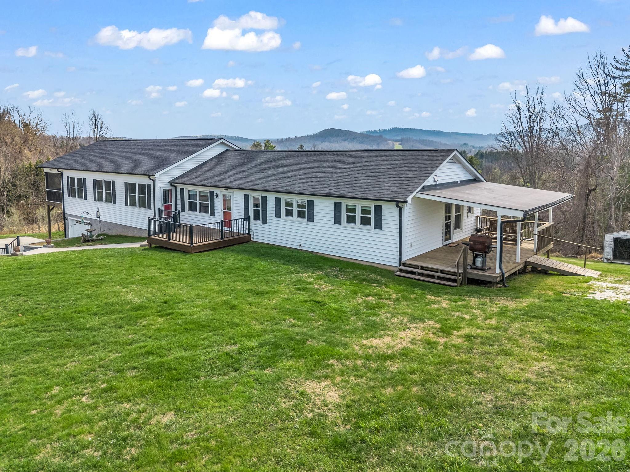 1086 Carters Ridge Road Spruce Pine, NC 28777 - Photo 40 of 48 a view of a house with a big yard and large trees