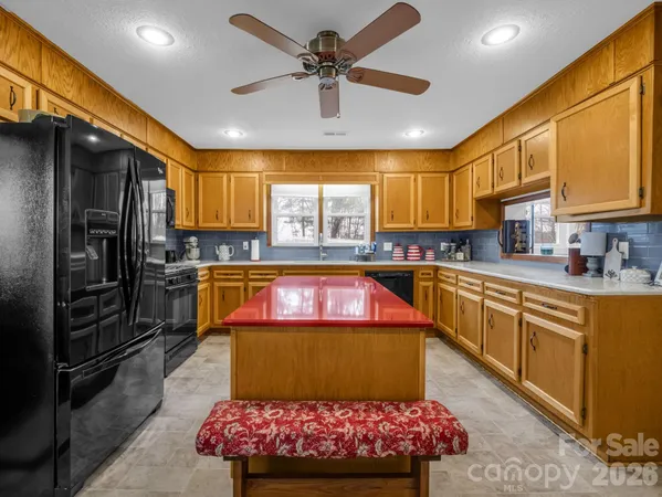 a kitchen with stainless steel appliances granite countertop a sink refrigerator and cabinets