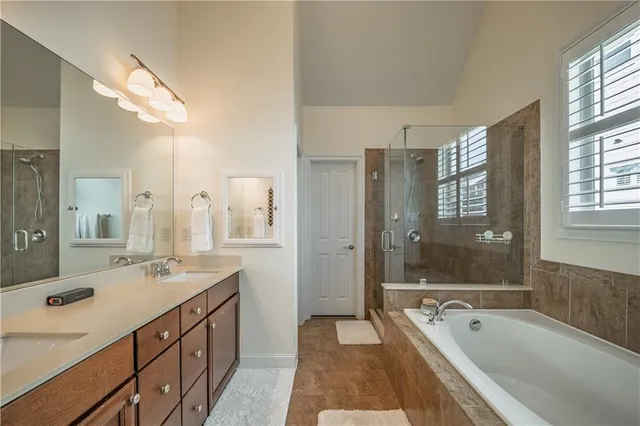 a spacious bathroom with a tub sink shower and mirror