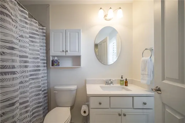 a bathroom with a sink mirror and toilet