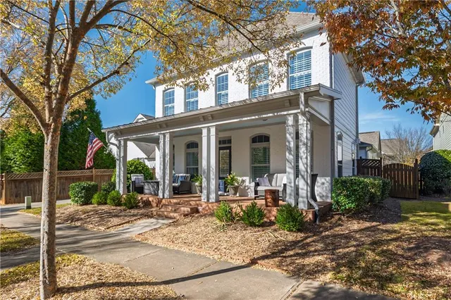 a view of a brick house with large windows and plants