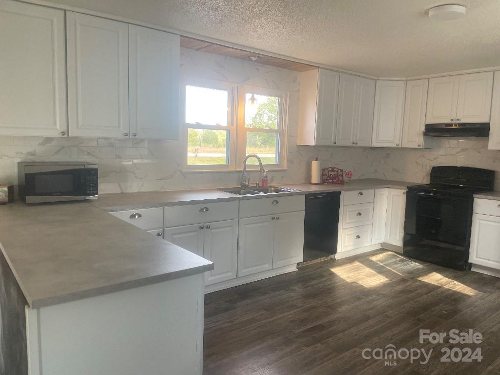 1329 Peach Orchard Road Union, SC 29379 - Photo 6 of 15 a kitchen with granite countertop a sink cabinets and wooden floor