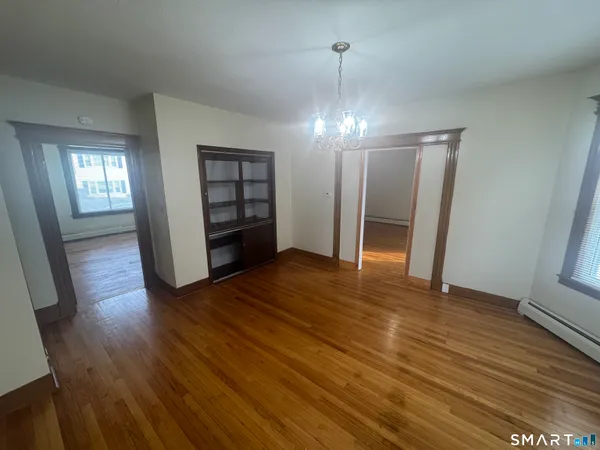 an empty room with wooden floor and window