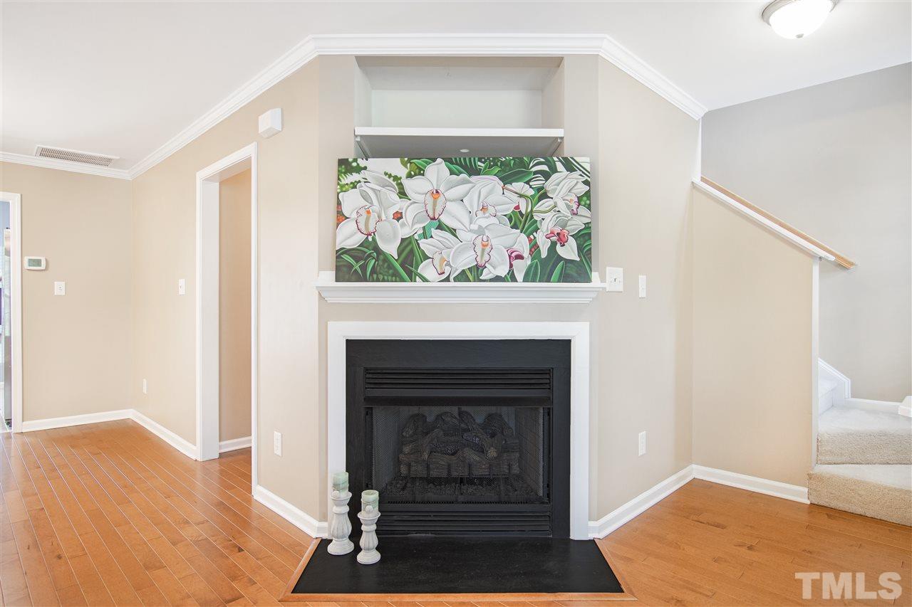 10032 Blackwell Drive Raleigh, NC 27617 - Photo 5 of 28 a living room with a fireplace and a wooden floor