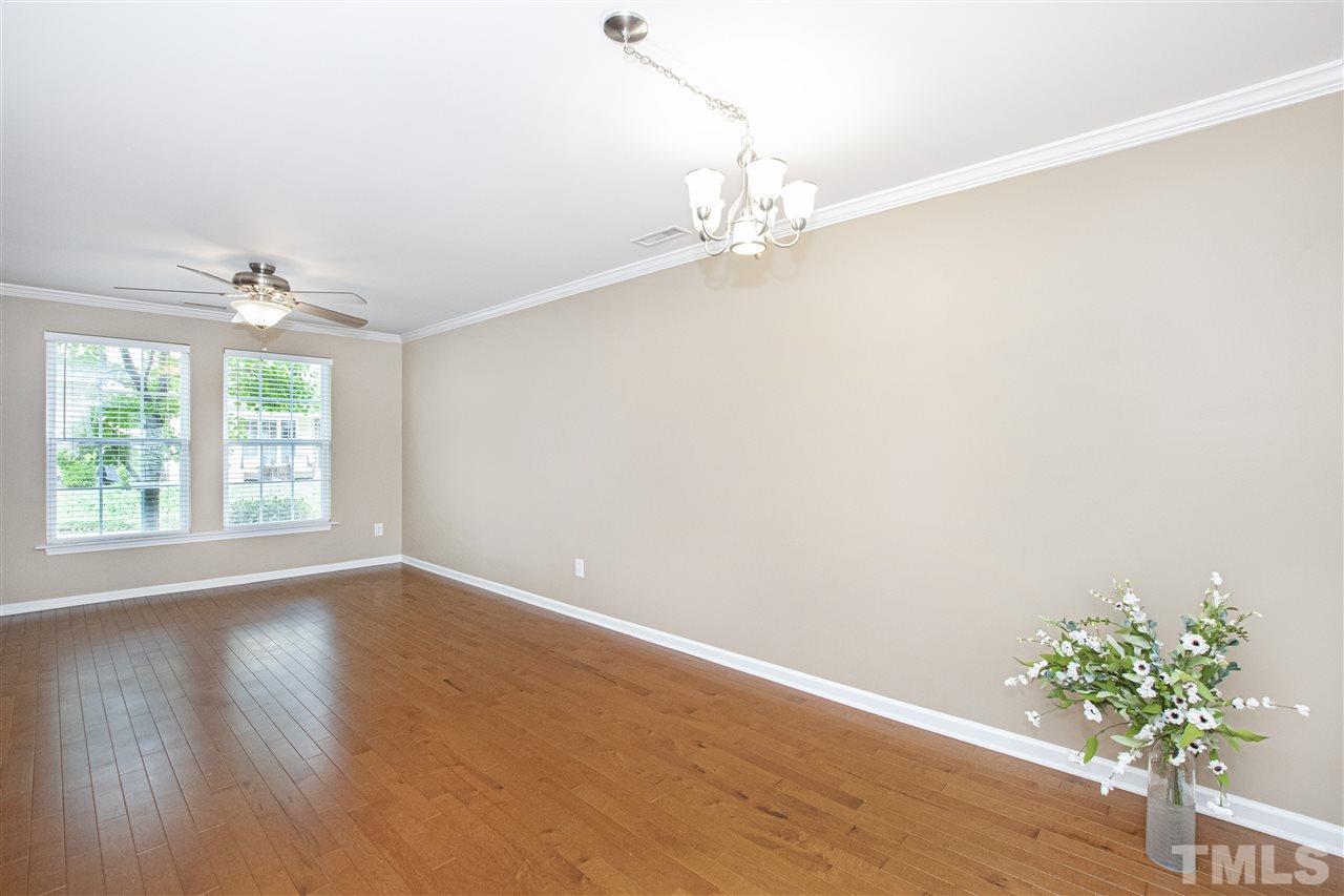 10032 Blackwell Drive Raleigh, NC 27617 - Photo 10 of 28 an empty room with wooden floor and chandelier