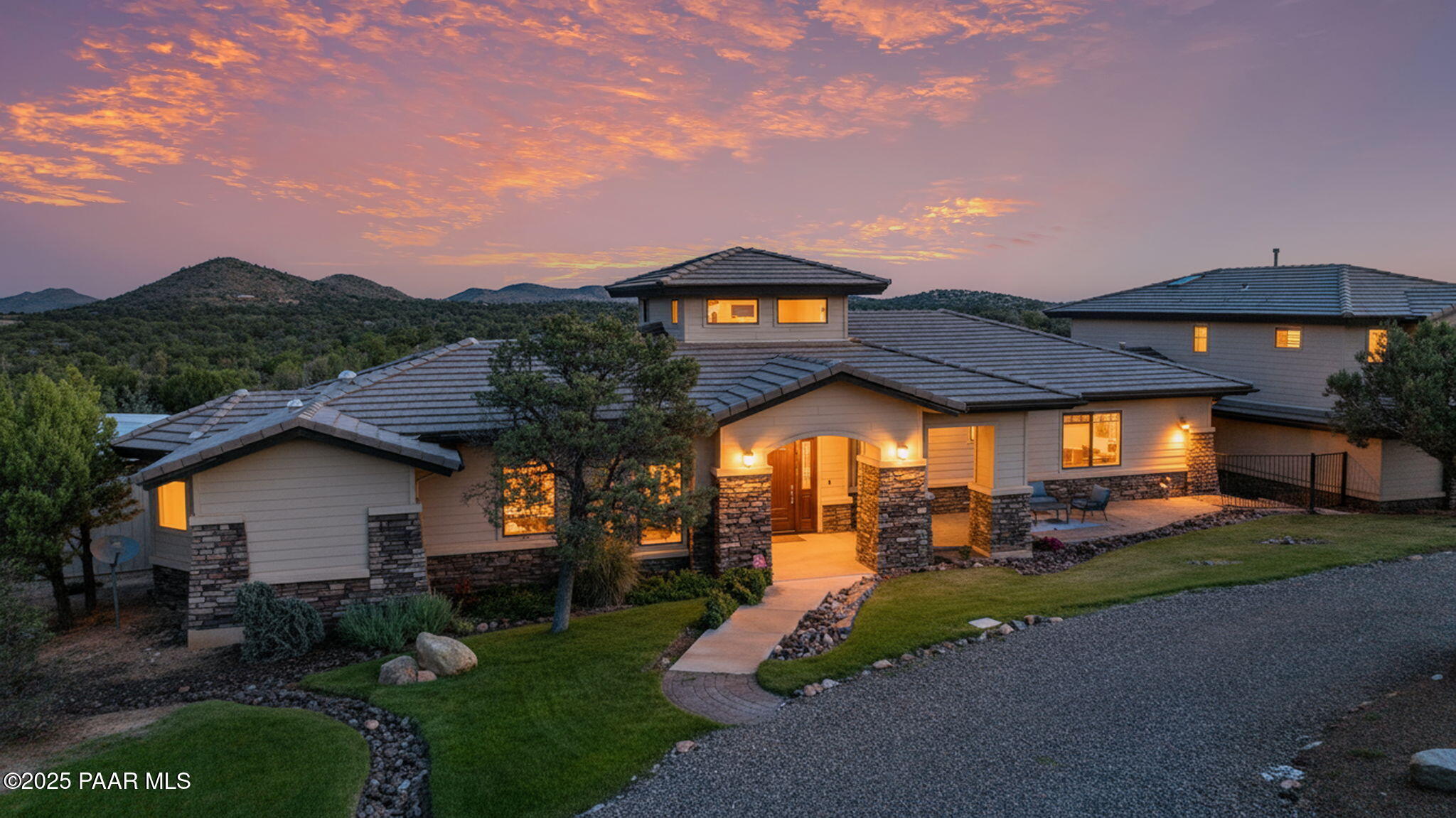 a view of a house with a yard and table and chairs under an umbrella
