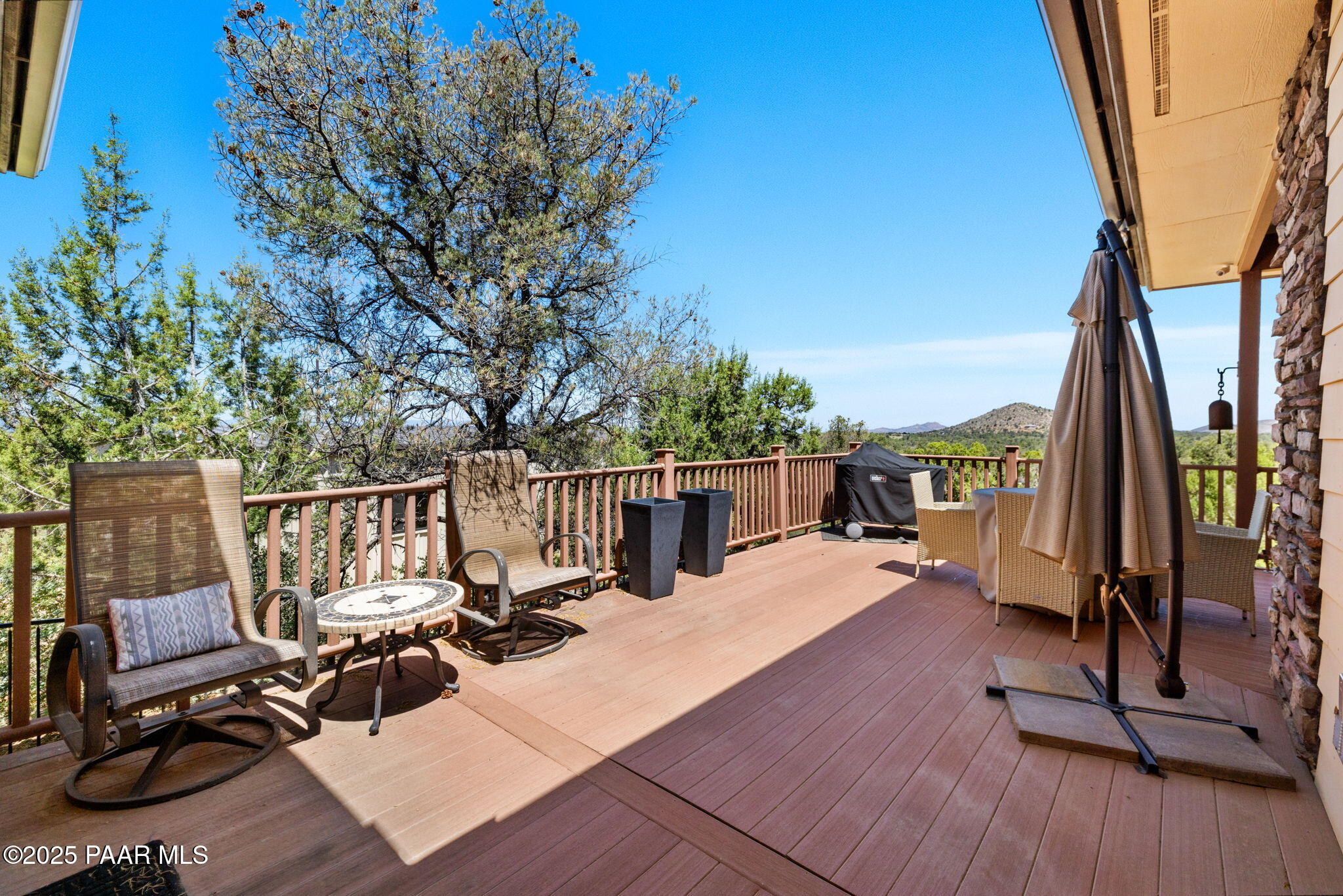 13175 North Bull Run Road Prescott, AZ 86305 - Photo 43 of 60 a view of a roof deck with table and chairs a barbeque with wooden floor and fence