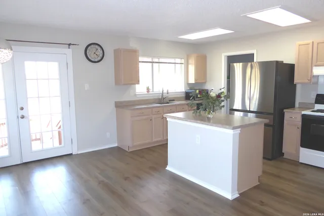a kitchen with a refrigerator and a stove top oven