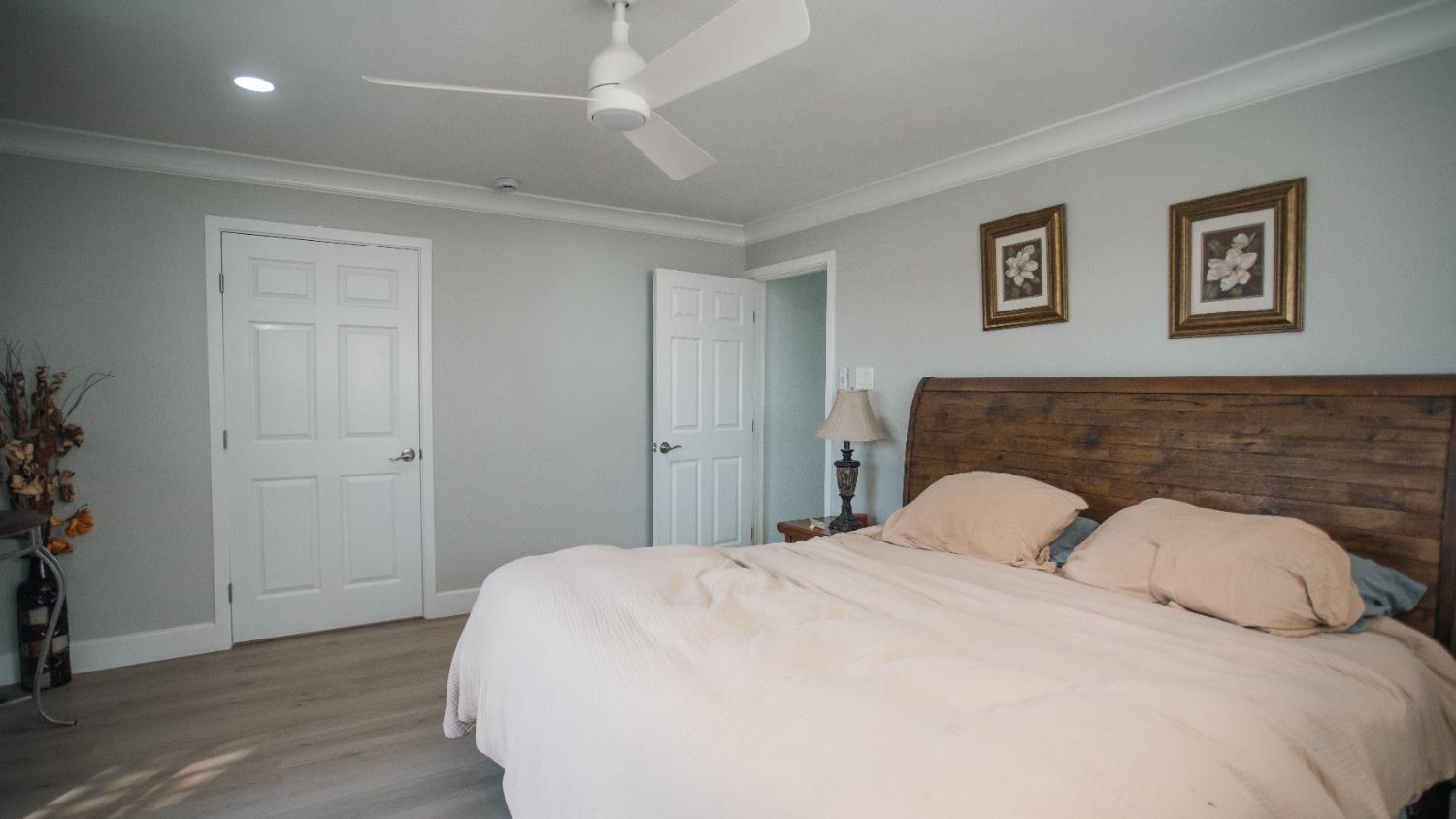 9115 East Southland Road Manteca, CA 95336 - Photo 13 of 52 a bedroom with a large bed and a chandelier