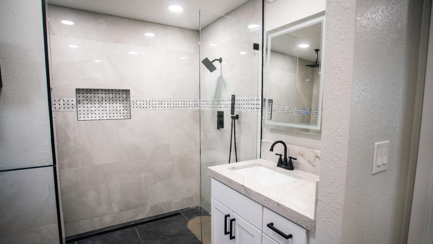 9115 East Southland Road Manteca, CA 95336 - Photo 20 of 52 a bathroom with a sink a mirror and shower