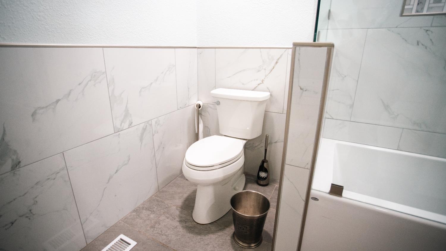 9115 East Southland Road Manteca, CA 95336 - Photo 25 of 52 a white toilet sitting next to a shower