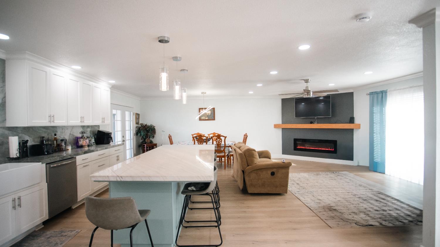 9115 East Southland Road Manteca, CA 95336 - Photo 28 of 52 a kitchen with stainless steel appliances a dining table chairs refrigerator and sink