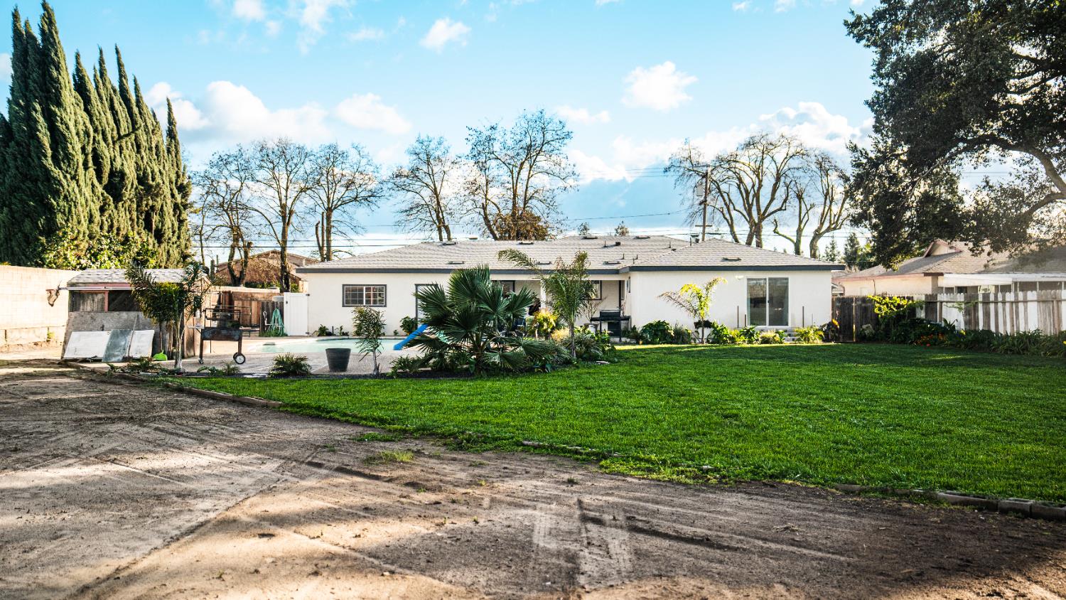 9115 East Southland Road Manteca, CA 95336 - Photo 44 of 52 a view of a white house next to a yard with big trees