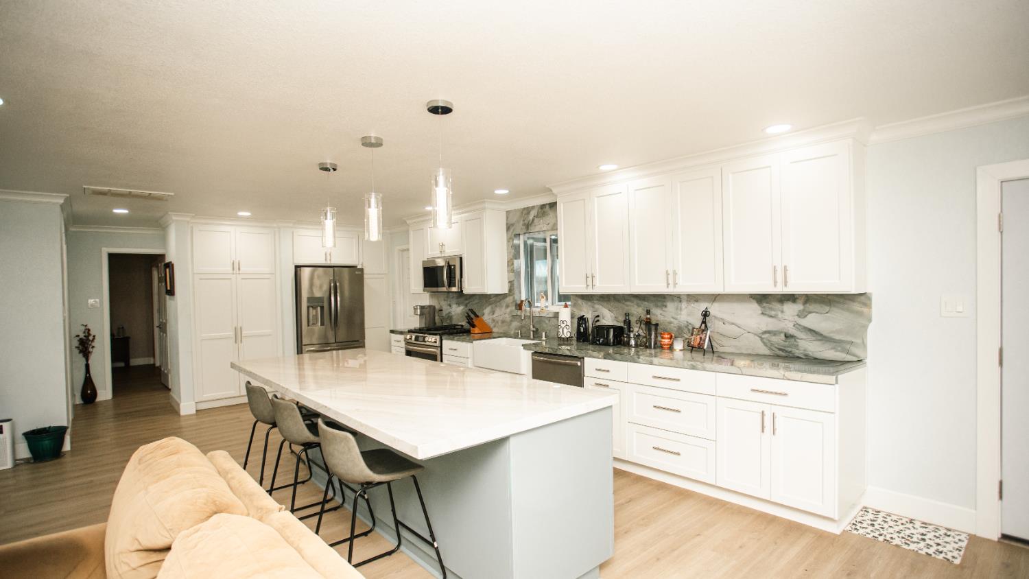 9115 East Southland Road Manteca, CA 95336 - Photo 8 of 52 a kitchen with a sink a stove a refrigerator and white cabinets with wooden floor