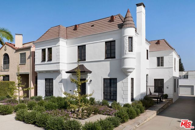 a front view of a house with plants