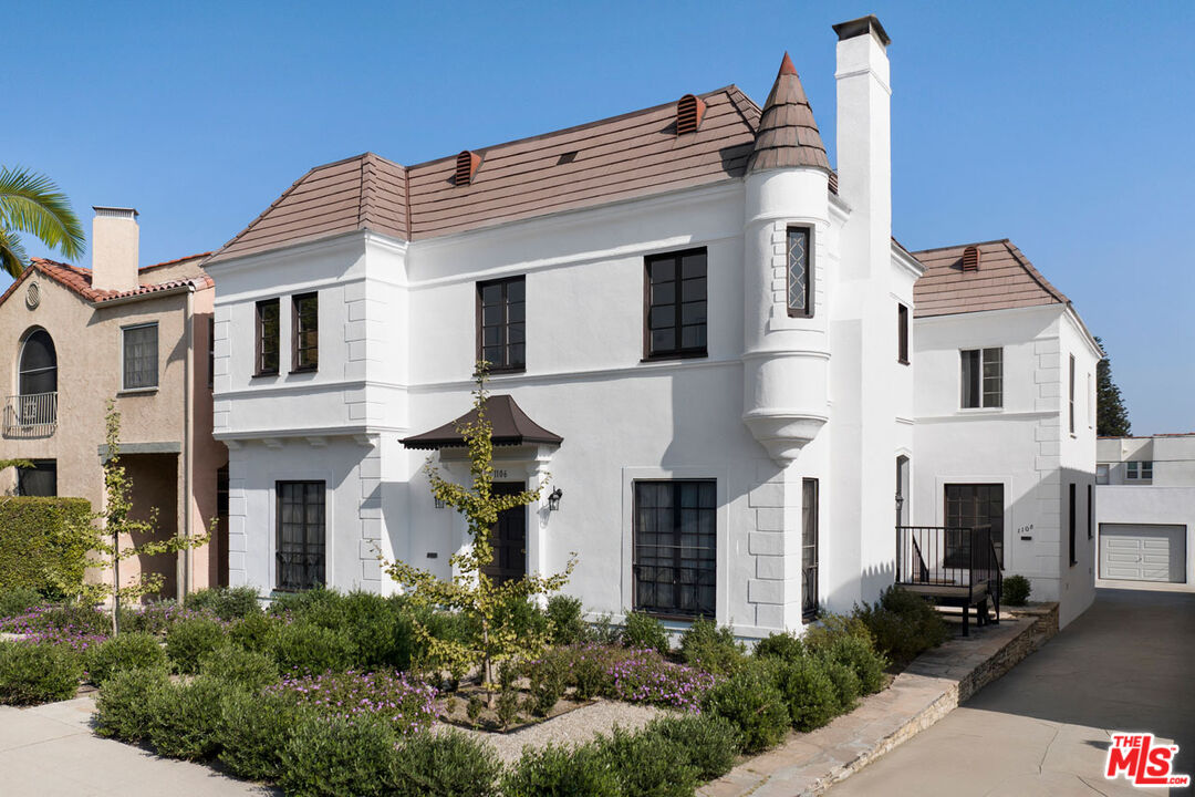 a front view of a house with plants