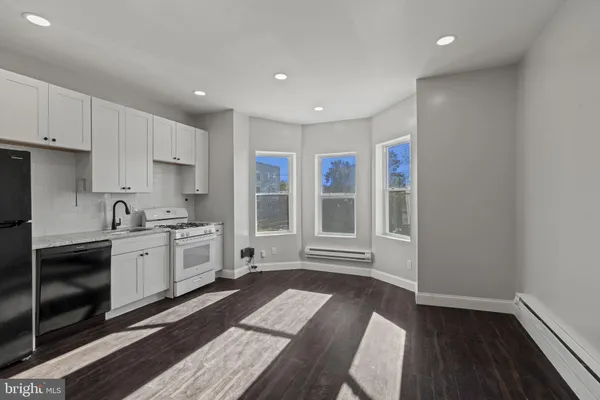 a kitchen with granite countertop a stove a sink and a refrigerator