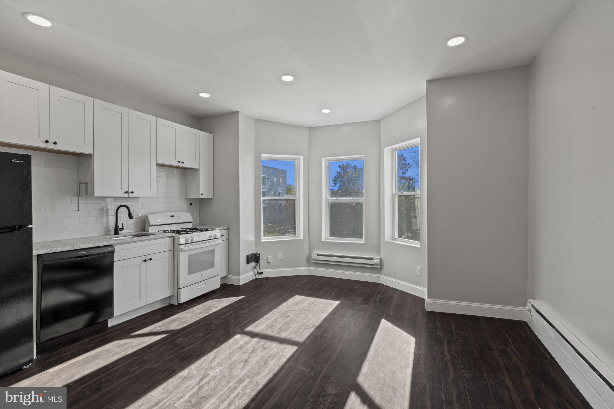 a kitchen with granite countertop a stove a sink and a refrigerator